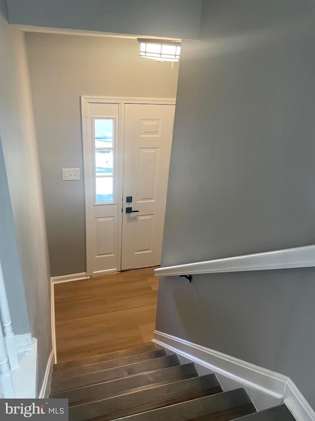 staircase with baseboards and wood finished floors