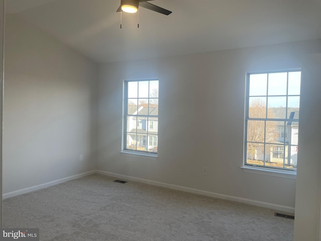 carpeted empty room with baseboards, visible vents, and ceiling fan