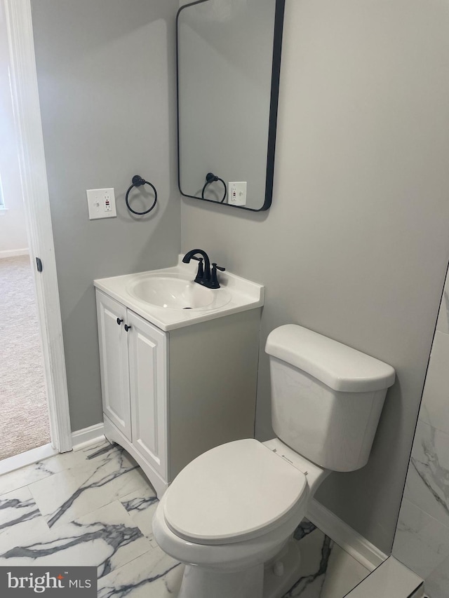 bathroom featuring marble finish floor, toilet, vanity, and baseboards