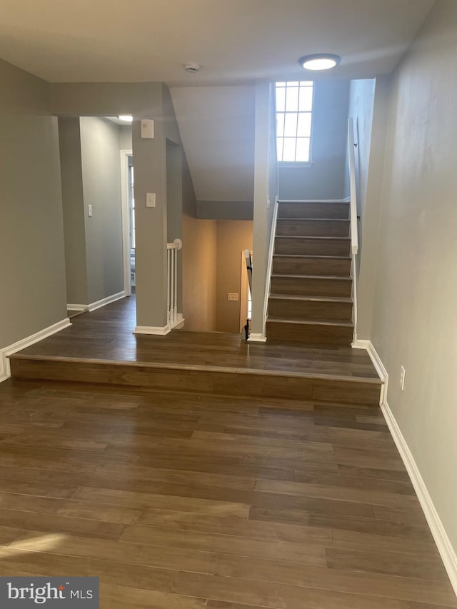 stairway featuring wood finished floors and baseboards