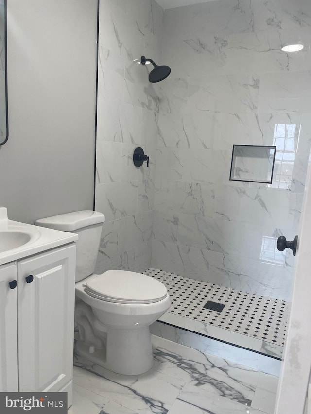 bathroom featuring vanity, marble finish floor, a shower stall, and toilet