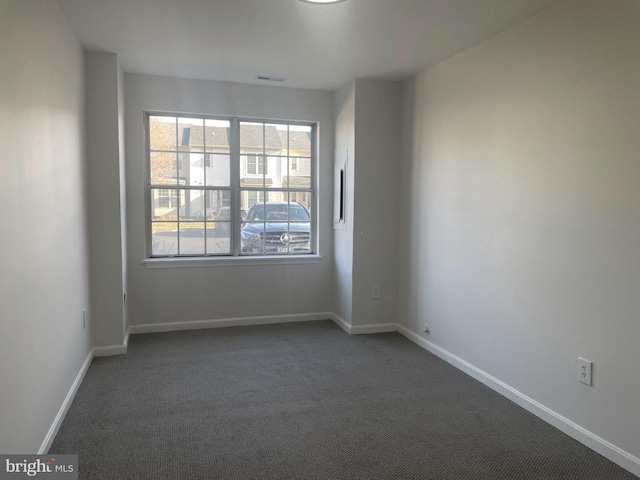 carpeted spare room with visible vents and baseboards