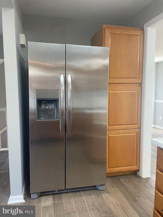 kitchen with stainless steel fridge with ice dispenser and wood tiled floor