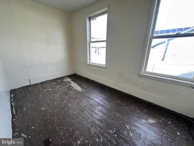 spare room with hardwood / wood-style flooring and baseboards