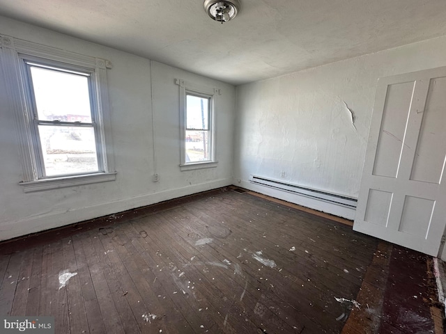 empty room featuring hardwood / wood-style flooring and baseboard heating