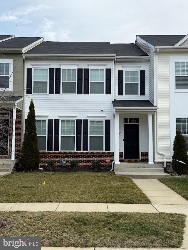 multi unit property featuring a front yard and brick siding