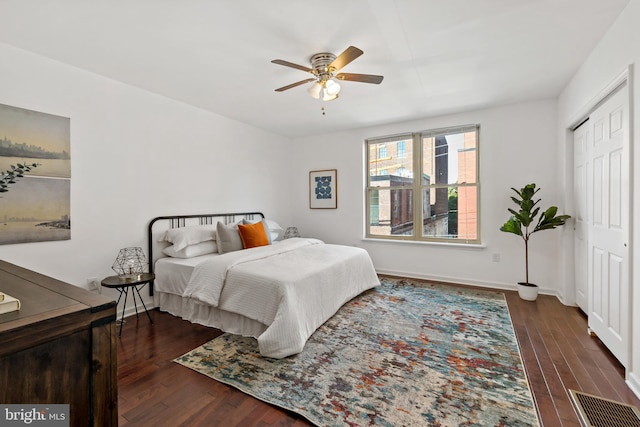 bedroom featuring a closet, ceiling fan, baseboards, and wood finished floors