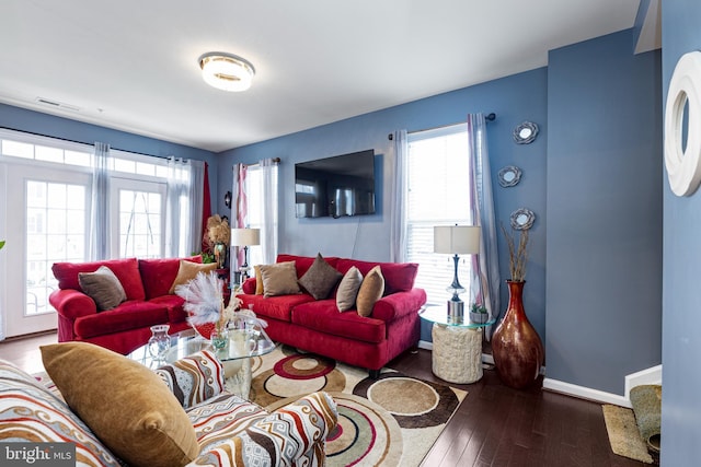 living room with baseboards, visible vents, and hardwood / wood-style floors