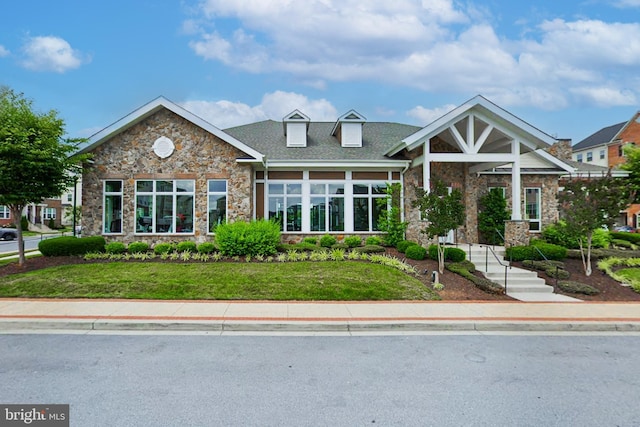 view of front of house with stone siding and a front lawn