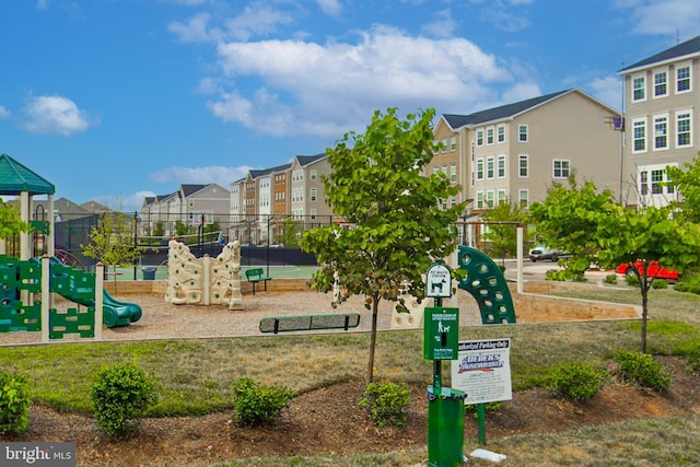 communal playground featuring a residential view and fence