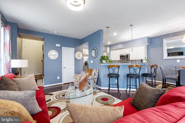 living area featuring recessed lighting, wood finished floors, visible vents, and baseboards