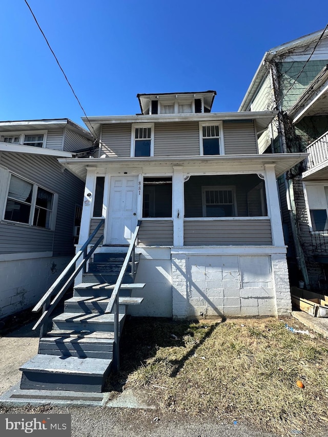 american foursquare style home featuring a porch and stairway