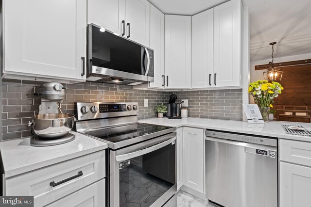 kitchen featuring marble finish floor, appliances with stainless steel finishes, and white cabinets