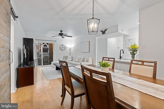 dining space with light wood-style floors, ceiling fan, and visible vents