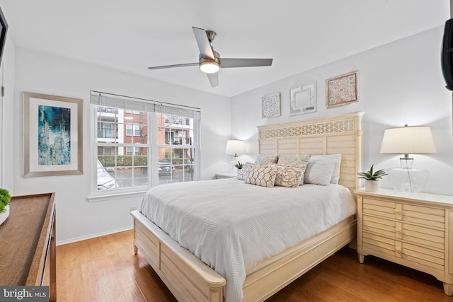 bedroom with ceiling fan, baseboards, and wood finished floors