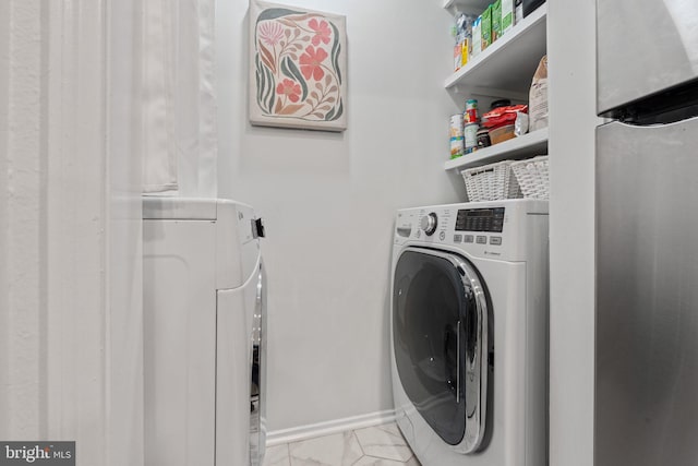 laundry area with laundry area, baseboards, marble finish floor, and washer and clothes dryer