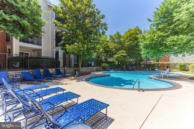 community pool with fence and a patio