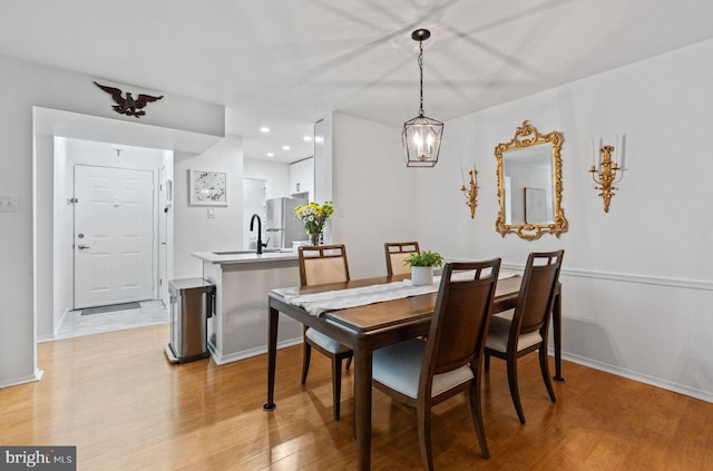 dining space with light wood-style floors, baseboards, and recessed lighting