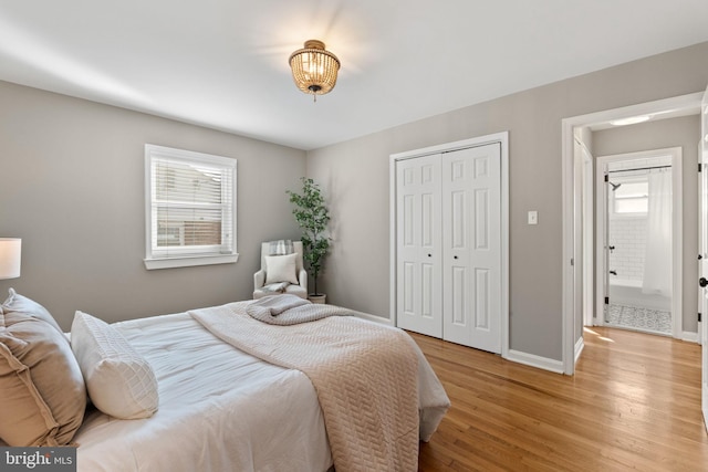 bedroom featuring light wood-type flooring, baseboards, and a closet