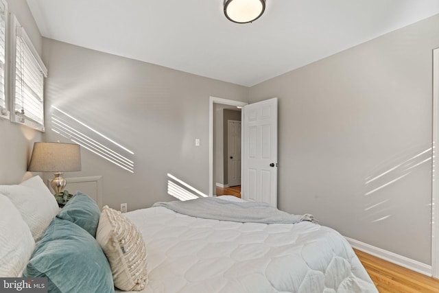 bedroom featuring baseboards and light wood finished floors