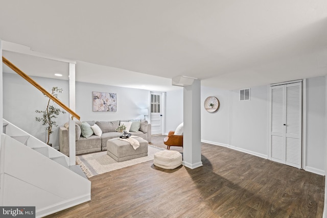 living room featuring stairs, wood finished floors, visible vents, and baseboards