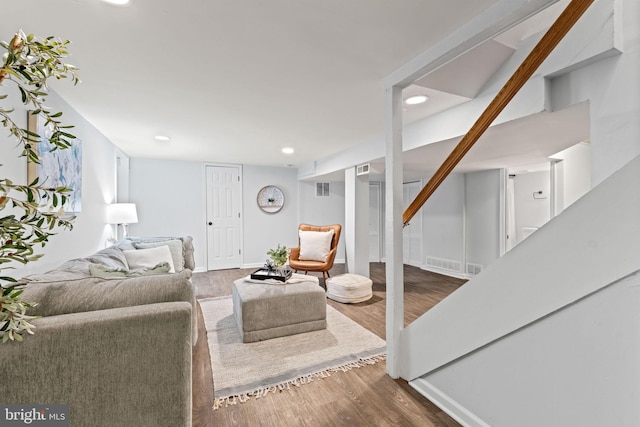 living area with recessed lighting, visible vents, baseboards, and wood finished floors