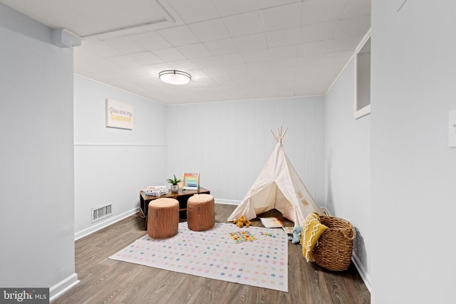 rec room with visible vents, baseboards, and wood finished floors