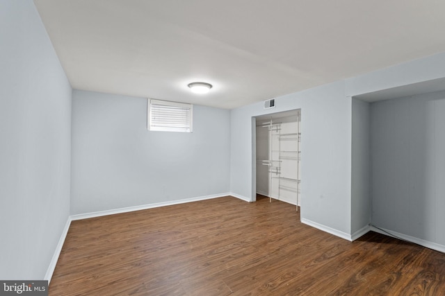 unfurnished bedroom with a closet, visible vents, baseboards, and wood finished floors