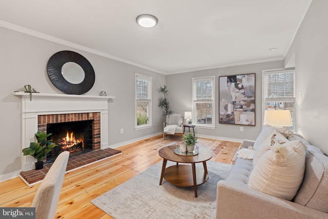 living area with ornamental molding, hardwood / wood-style floors, a brick fireplace, and baseboards