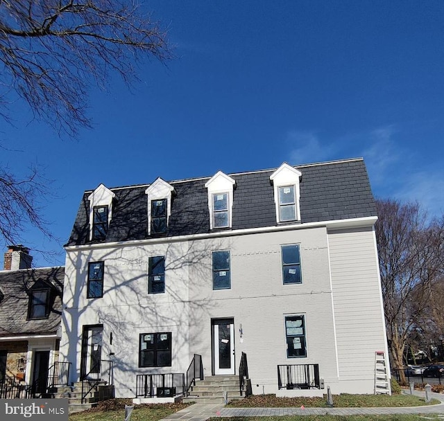 view of front of house featuring mansard roof