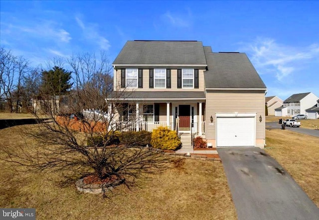 colonial home featuring covered porch, aphalt driveway, a front lawn, and an attached garage