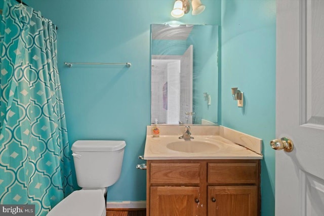 bathroom featuring a shower with shower curtain, vanity, and toilet