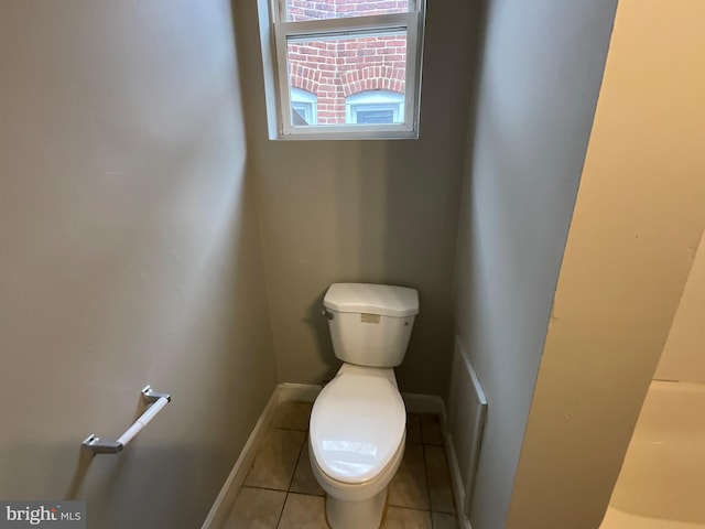 bathroom with tile patterned floors, baseboards, and toilet