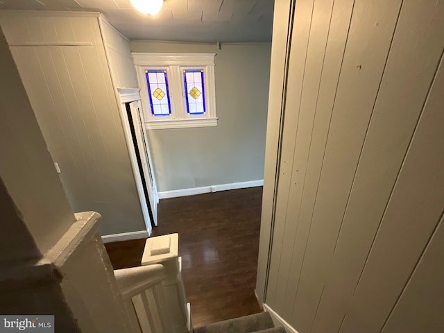 hallway with baseboards and dark wood-style flooring