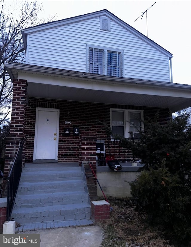 view of front facade with a porch and brick siding