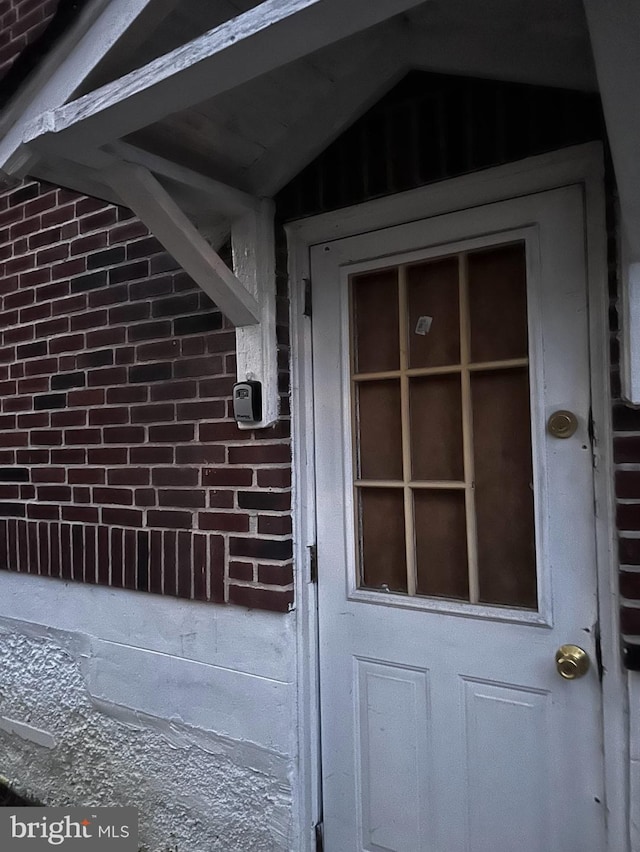 doorway to property featuring brick siding