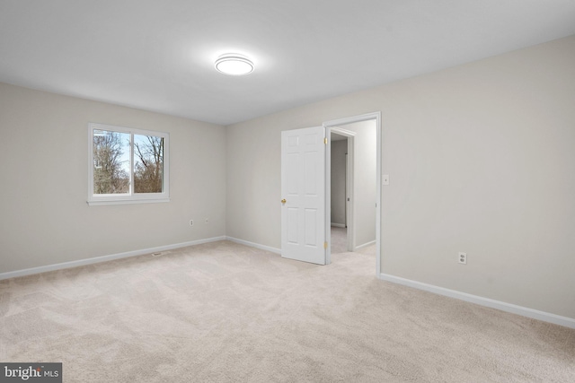 unfurnished bedroom featuring baseboards and light colored carpet