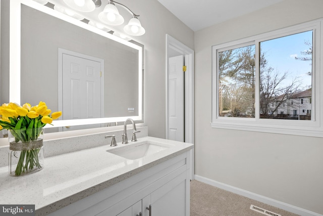 bathroom with vanity, visible vents, and baseboards