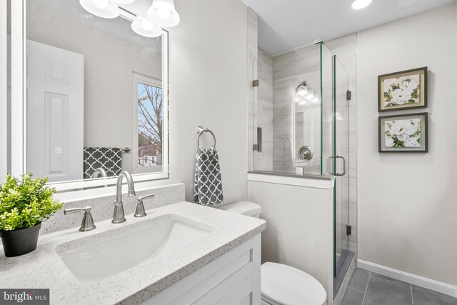 bathroom featuring vanity, a shower stall, toilet, and tile patterned floors