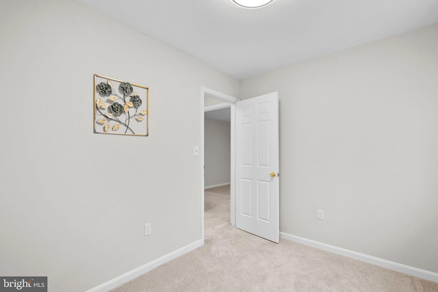 unfurnished bedroom with baseboards and light colored carpet