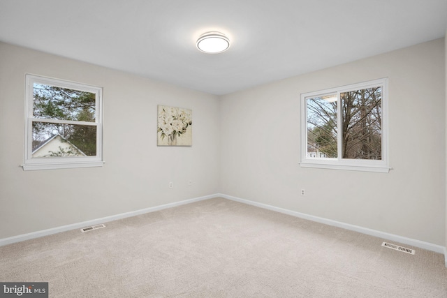 unfurnished room featuring baseboards, visible vents, and carpet flooring