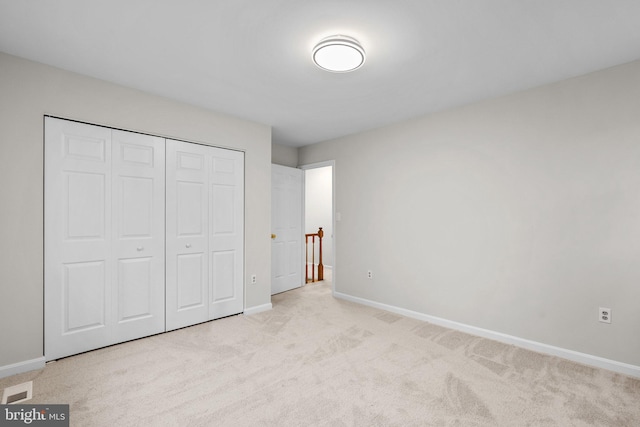 unfurnished bedroom featuring carpet, a closet, and baseboards