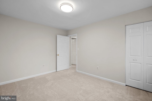 unfurnished bedroom with carpet, baseboards, and a closet