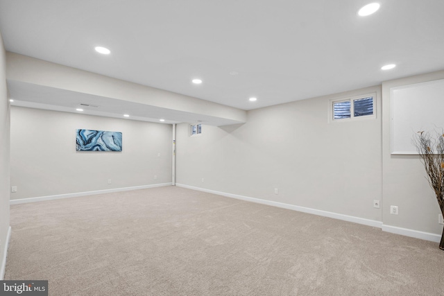 finished basement featuring light carpet, baseboards, and recessed lighting