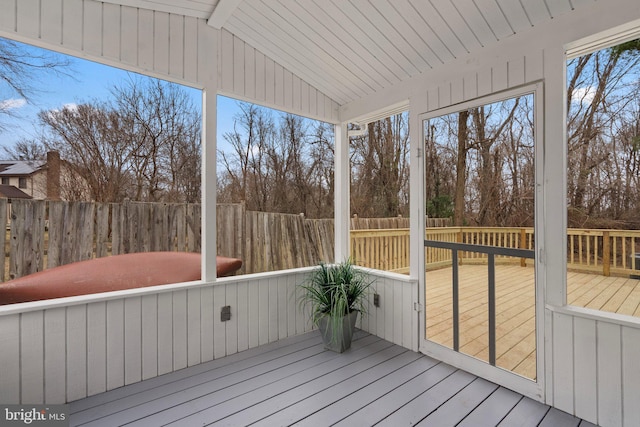 unfurnished sunroom with vaulted ceiling with beams