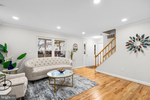 living room featuring crown molding, visible vents, stairway, wood finished floors, and baseboards