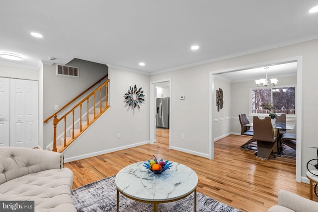 living area featuring stairs, light wood-style flooring, ornamental molding, and visible vents