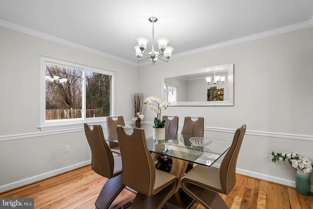 dining space featuring ornamental molding, a notable chandelier, baseboards, and wood finished floors