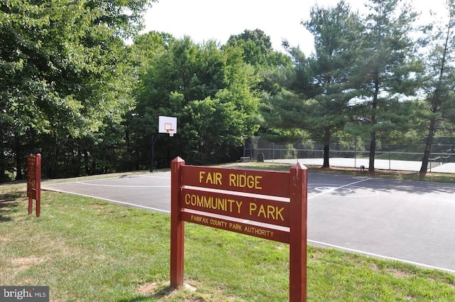 community sign with fence and a yard