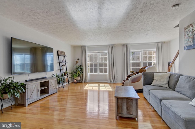 living area featuring light wood-style floors and a textured ceiling